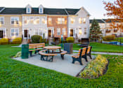 Thumbnail 40 of 50 - a picnic area with benches in front of an apartment building at Townes at Village Center Apartments, Reisterstown