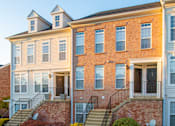 Thumbnail 44 of 50 - a large brick building with stairs in front of it at Townes at Village Center Apartments, Reisterstown, MD, 21136