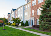 Thumbnail 43 of 50 - Building exterior with garden and trees at Townes at Village Center Apartments, Maryland, 21136