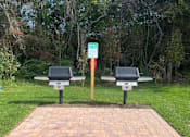 Thumbnail 21 of 35 - Two benches are placed on a brick pathway in a park at The Promenade at Easton Apartments, Maryland, 21601