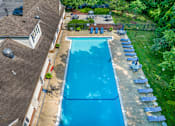 Thumbnail 33 of 35 - A large blue swimming pool surrounded by lawn chairs and trees. at Spa Cove Apartments, Annapolis, 21403