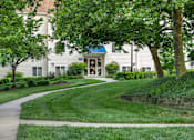 Thumbnail 16 of 24 - A building with a blue sign on it is surrounded by greenery. at West Woods, Annapolis, Maryland