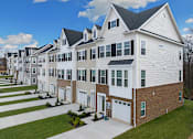 Thumbnail 3 of 20 - A large white house with a black roof and a garage door.at Forge Overlook, Halethorpe
