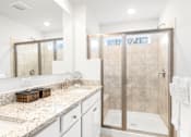 Thumbnail 13 of 20 - A bathroom with a walk-in shower and a vanity with a marble countertop.at Forge Overlook, Halethorpe, MD