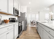 Thumbnail 5 of 20 - A modern kitchen with white cabinets and stainless steel appliances.at Forge Overlook, Halethorpe