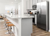 Thumbnail 4 of 20 - A modern kitchen with a bar and stools.at Forge Overlook, Maryland, 21227