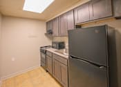 Thumbnail 9 of 14 - A kitchen with a black refrigerator and stainless steel appliances.