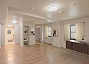 Thumbnail 14 of 14 - A spacious room with wooden floors and white walls.