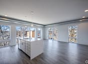 Thumbnail 8 of 19 - A large, empty room with a kitchen island in the middle.