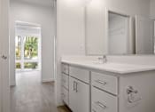 Thumbnail 14 of 19 - A white bathroom with a sink, mirror, and cabinets.