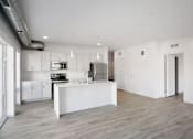Thumbnail 16 of 19 - A modern kitchen with white cabinets and a white island.