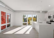 Thumbnail 18 of 19 - A kitchen with a white counter and a window with red leaves.