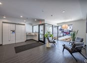 Thumbnail 9 of 19 - A modern office lobby with a black bench and a brown rug.