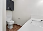 Thumbnail 50 of 52 - A white toilet sits next to a white sink in a bathroom.