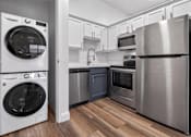 Thumbnail 38 of 52 - A modern kitchen with a washing machine and a refrigerator.