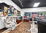 Thumbnail 29 of 52 - A room with a large tree trunk sculpture and a shelf filled with various bottles.