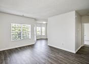 Thumbnail 52 of 61 - A spacious room with wooden floors and white walls.