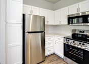 Thumbnail 43 of 61 - A kitchen with a stainless steel refrigerator, microwave, and oven.