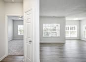 Thumbnail 51 of 61 - A room with a carpeted floor and a door leading to another room.
