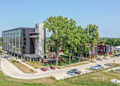 Thumbnail 8 of 50 - A modern building with a parking lot in front.