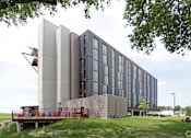 Thumbnail 9 of 50 - A modern building with a combination of grey and black panels.