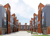 Thumbnail 17 of 50 - A series of modern buildings with red and grey exteriors.