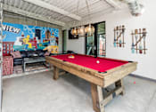Thumbnail 24 of 50 - A pool table in a room with a mural on the wall.