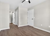 Thumbnail 14 of 52 - A room with a white door and a ceiling fan.