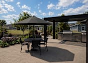 Thumbnail 33 of 35 - A patio with a table and chairs under a gazebo.
