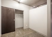 Thumbnail 13 of 35 - A room with a brown door and a white wall.