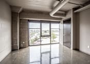 Thumbnail 8 of 35 - A large empty room with a view of the outside through the glass doors.