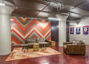 Thumbnail 23 of 35 - A room with a chevron patterned wall and a couch.