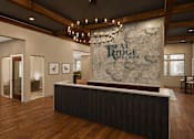 Thumbnail 11 of 35 - A reception area for Real Ridge Village Community with a stone backdrop and a black reception desk.
