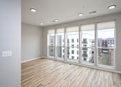 Thumbnail 6 of 34 - A room with a large window and wooden flooring.