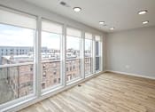 Thumbnail 7 of 34 - A room with a view of a cityscape through large windows.