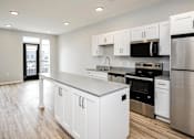 Thumbnail 17 of 34 - A kitchen with white cabinets and stainless steel appliances.