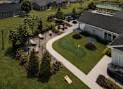 Thumbnail 13 of 35 - A golf course is surrounded by a green lawn and a few buildings.