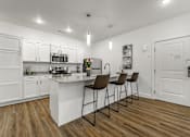 Thumbnail 4 of 28 - A kitchen with white cabinets and a wooden floor.