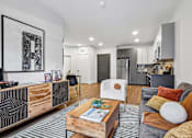 Thumbnail 41 of 43 - A modern living room with a grey couch and a wooden coffee table.