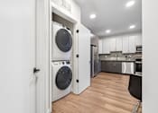 Thumbnail 16 of 43 - A modern laundry room with a washer and dryer built into the cabinetry.