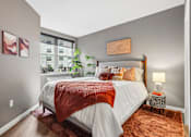 Thumbnail 43 of 43 - A bedroom with a large bed and a window overlooking a cityscape.
