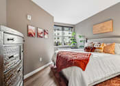 Thumbnail 18 of 43 - A bedroom with a large bed and a wooden dresser.