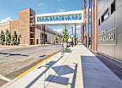 Thumbnail 42 of 43 - A street view with a pedestrian crossing and a building with a sign that says "The Standard".