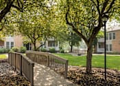 Thumbnail 9 of 22 - A tree-lined walkway leads to a building. at Brookfield Apartments, Macungie, PA