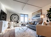 Thumbnail 10 of 22 - A living room with a grey couch, a coffee table, and a large painting on the wall at Cityplace Apartment Homes Apartments, Pennsylvania