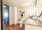 Thumbnail 15 of 22 - A bathroom with a toilet, sink, and mirror at Cityplace Apartment Homes Apartments, Pennsylvania