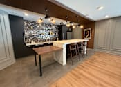 Thumbnail 12 of 15 - A modern kitchen with a wooden table and chairs.