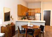 Thumbnail 9 of 26 - A modern kitchen with a wooden table and chairs. at The Hive Apartments, Allentown, Pennsylvania