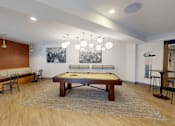 Thumbnail 25 of 35 - A pool table is in the middle of a room with a bench and chairs at The Standard Apartments, Pennsylvania, 18101