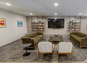 Thumbnail 24 of 35 - A living room with a green couch, two chairs, and a coffee table at The Standard Apartments, Pennsylvania